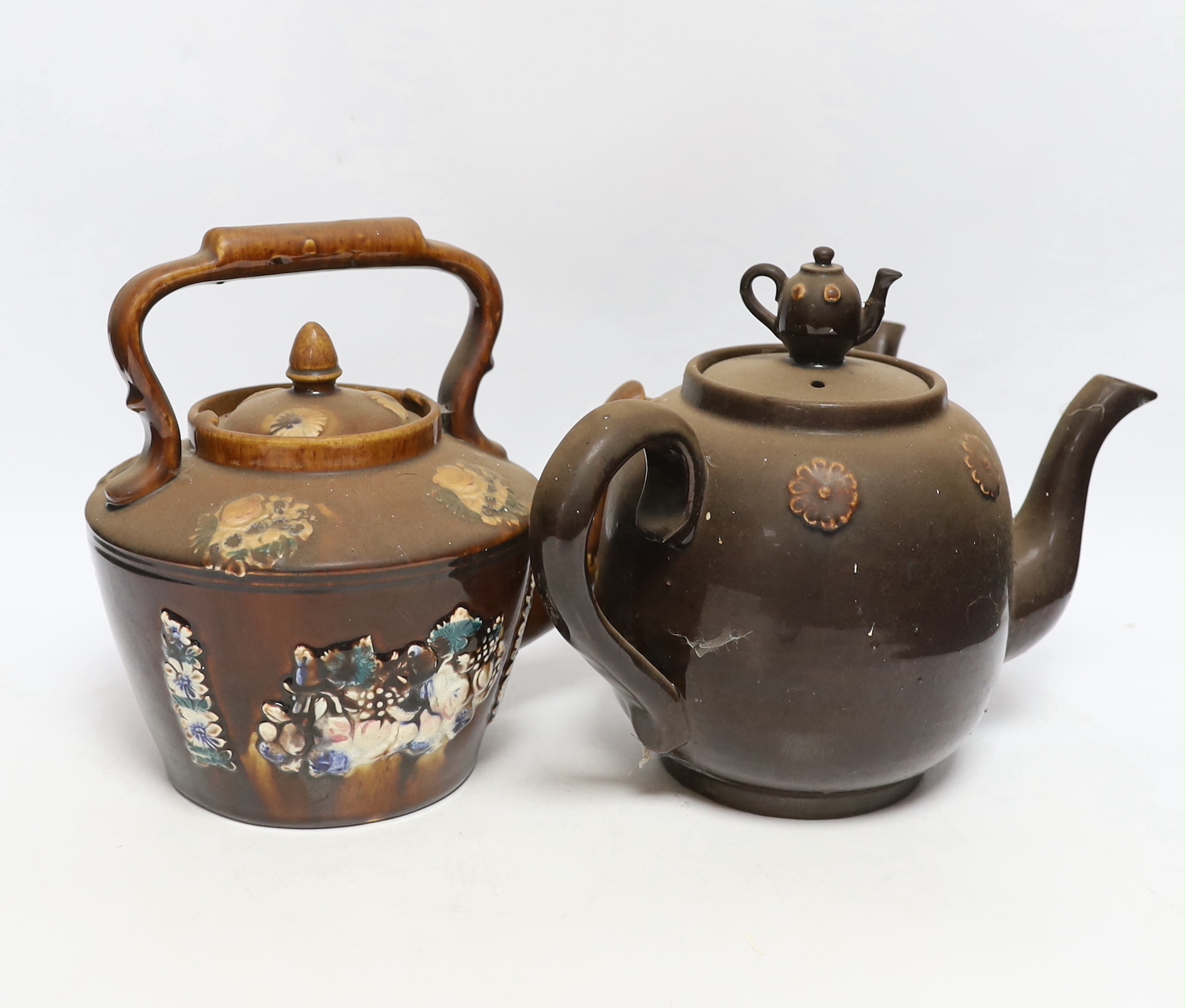 Two Measham Barge ware glazed pottery teapots, decorated in relief, largest 24cm wide